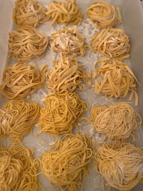 Nests of freshly rolled handmade tagliatelle and spaghetti dusted with flour
